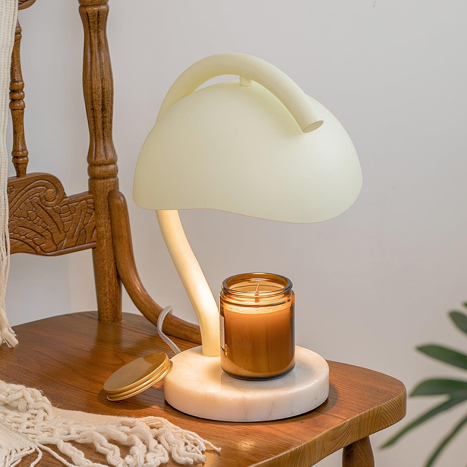 Contemporary candle warming table lamp with beige and white alabaster finish displayed in three-quarter view on vintage wooden furniture