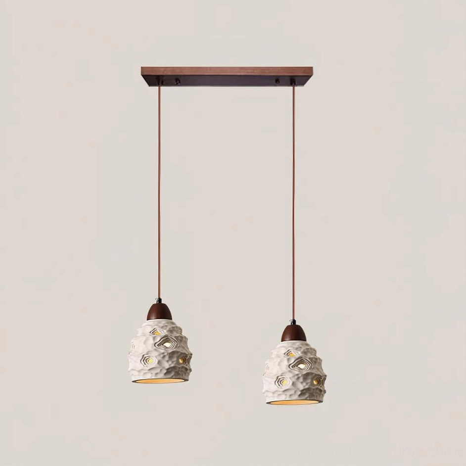 2-head linear ceramic pendant light hanging over dining area with dual sculptural shades and warm illumination