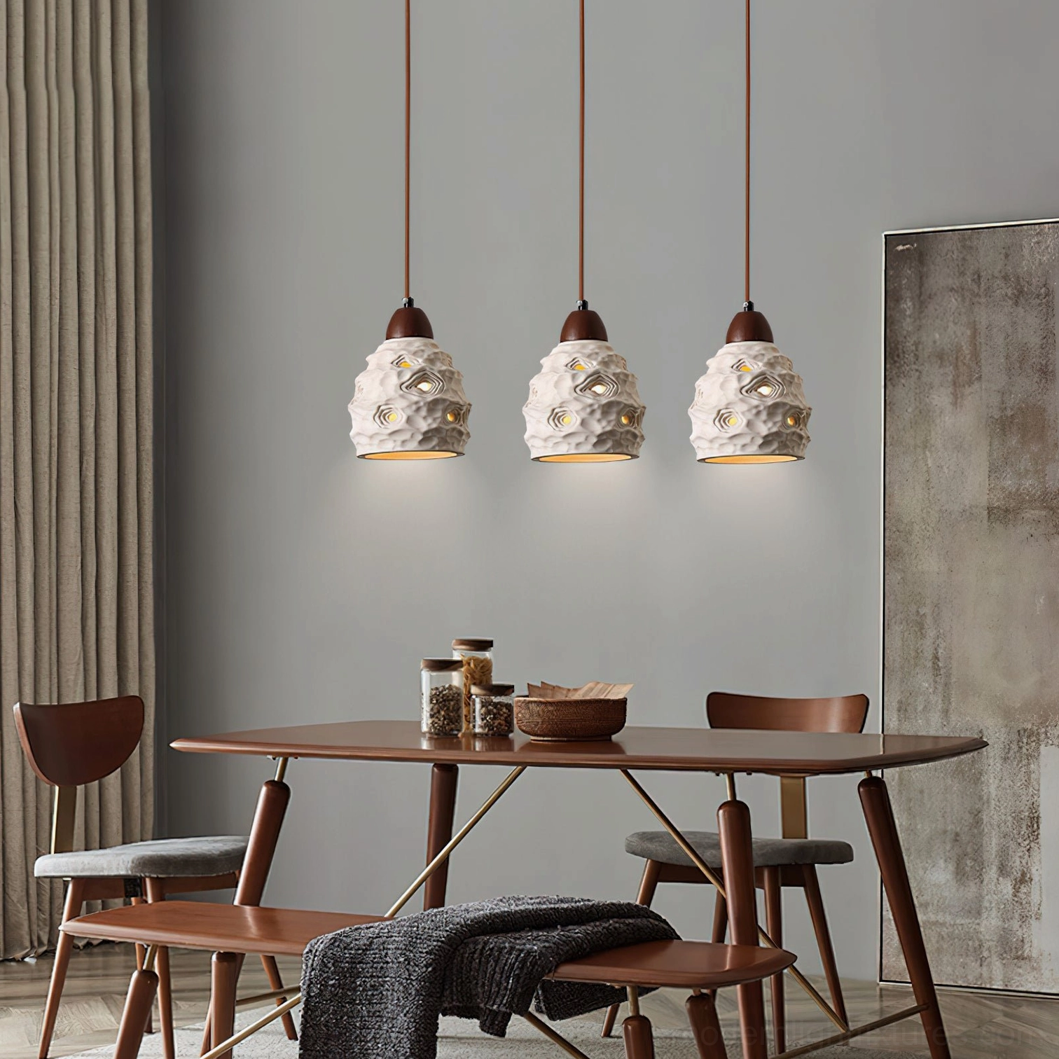 3-head ceramic pendant light set in modern dining room with matching off-white perforated shades and brown wood tops