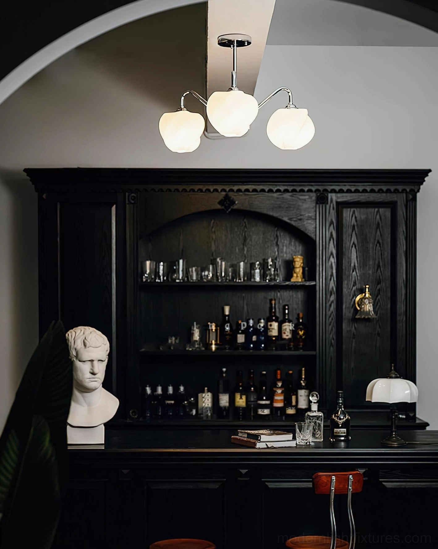 3-head pendant chandelier with warm glowing frosted shades and vintage luxury chrome design installed in classic home bar with decorative statue