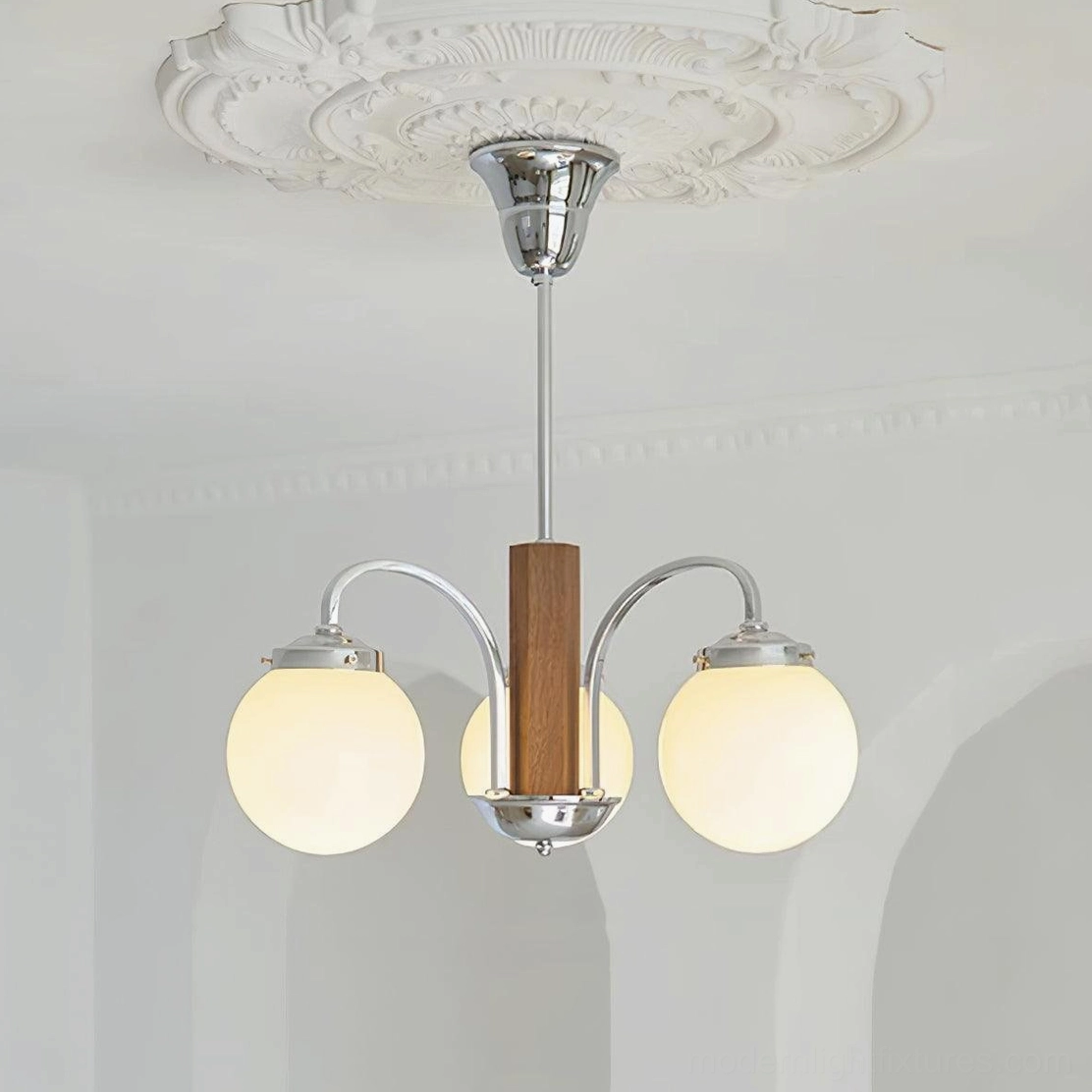3-light Polaris Bauhaus chandelier lit overhead view minimalist white arched interior ambient glow