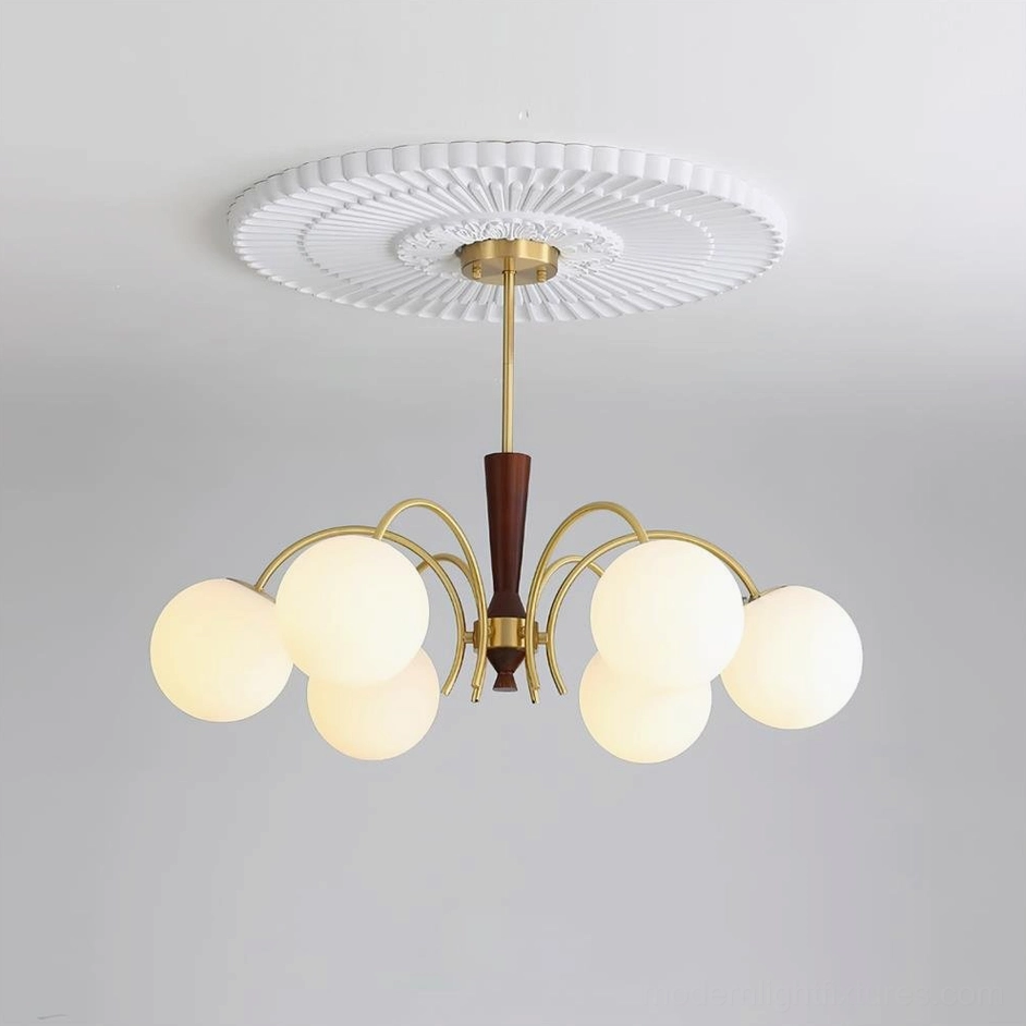Illuminated 6-head globe chandelier with warm glowing frosted glass shades and decorative brass ceiling medallion