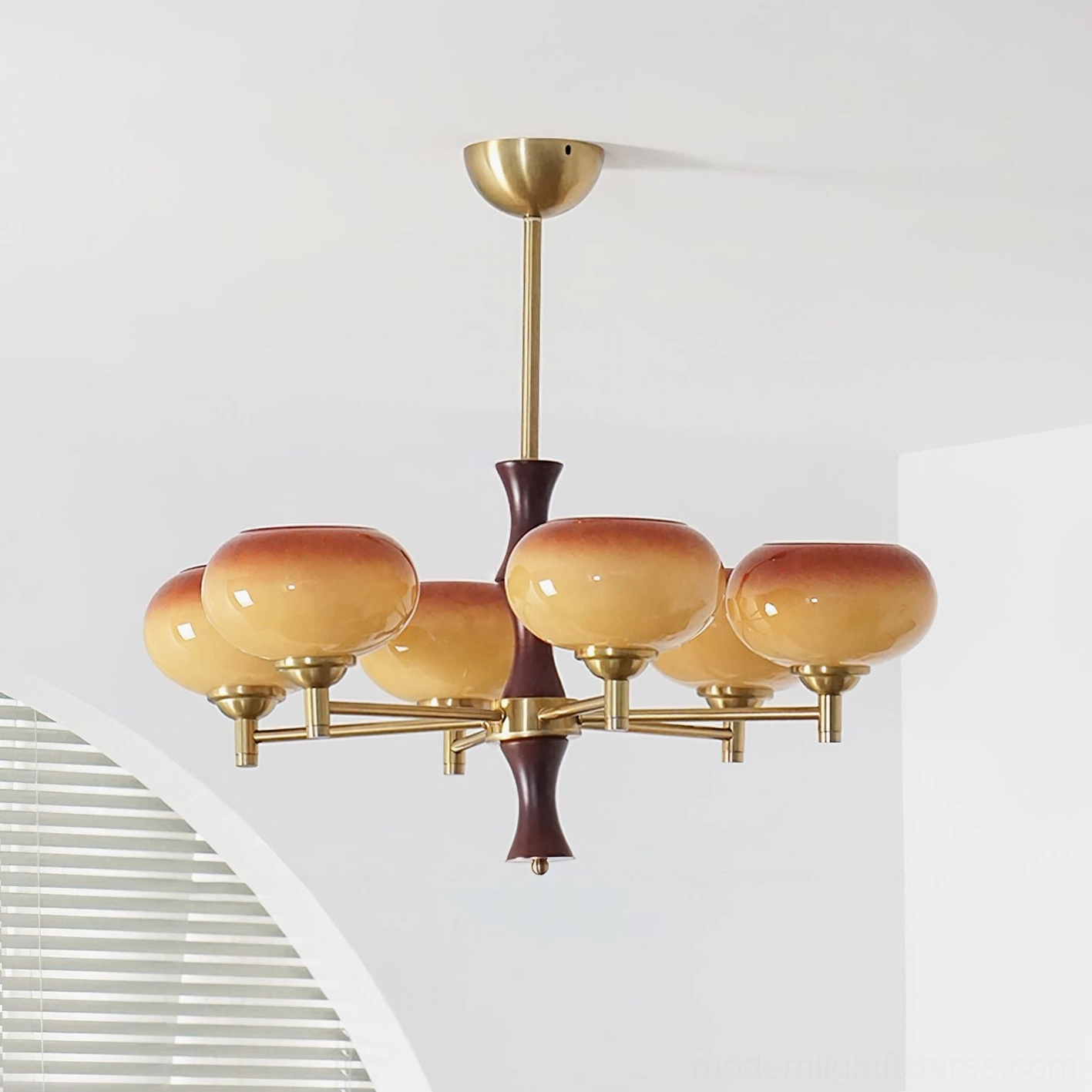 6-head vintage chandelier with solid warm beige glass shades, brass frame, and dark wood central post in home interior setting