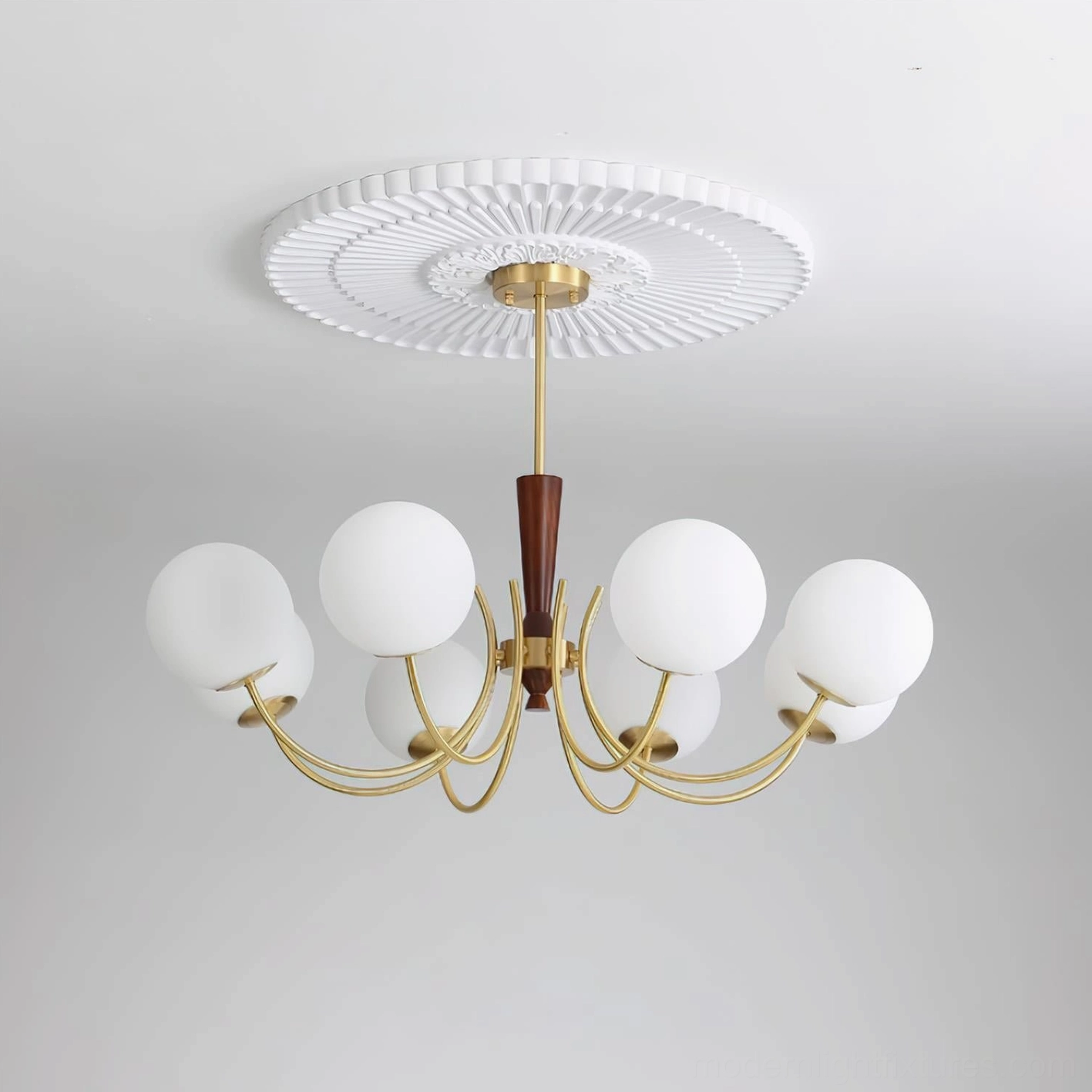 Unlit 8-head globe chandelier with matte frosted white glass shades and brass frame against grey background