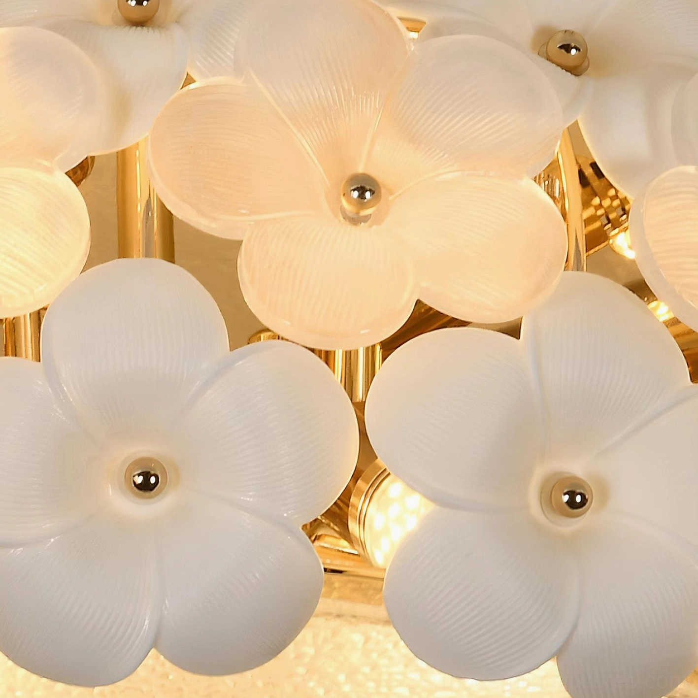 Close-up detail of Abella ceramic white flowers with gold mounting hardware showing handcrafted petal work