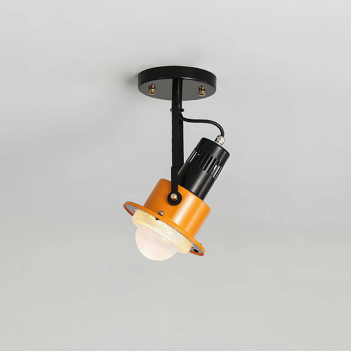 Side view of black metal adjustable spotlight arm with orange pendant shade, exposed bulb design