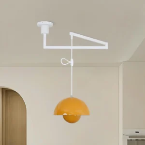 Adjustable swing arm pendant light with warm yellow glossy dome shade in minimalist kitchen dining area