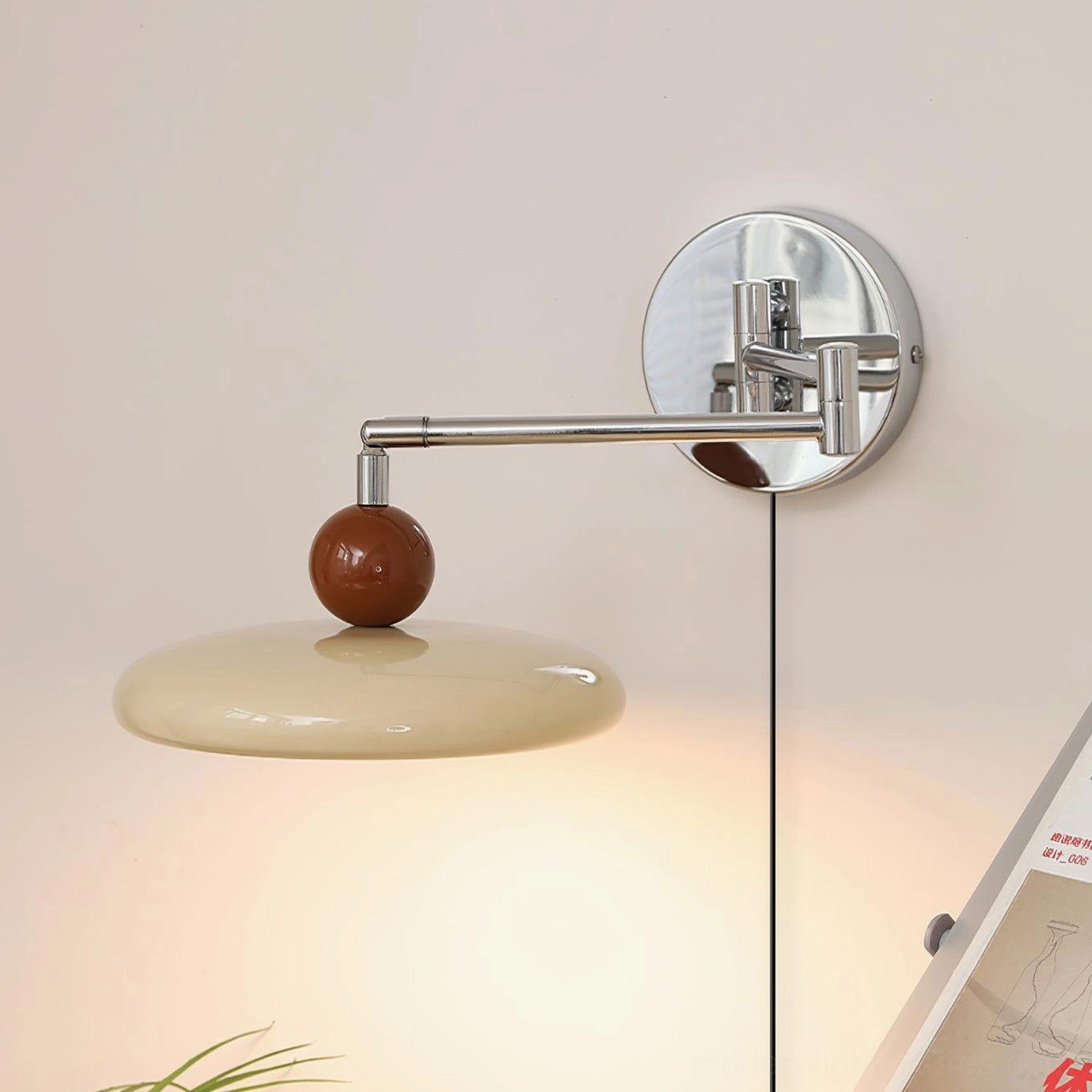 Beige disc shade plug-in wall sconce with adjustable chrome arm and wooden ball accent, warm studio lighting close-up