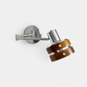 Modern adjustable wall sconce with chrome metal body and walnut wood base, side frontal view studio shot