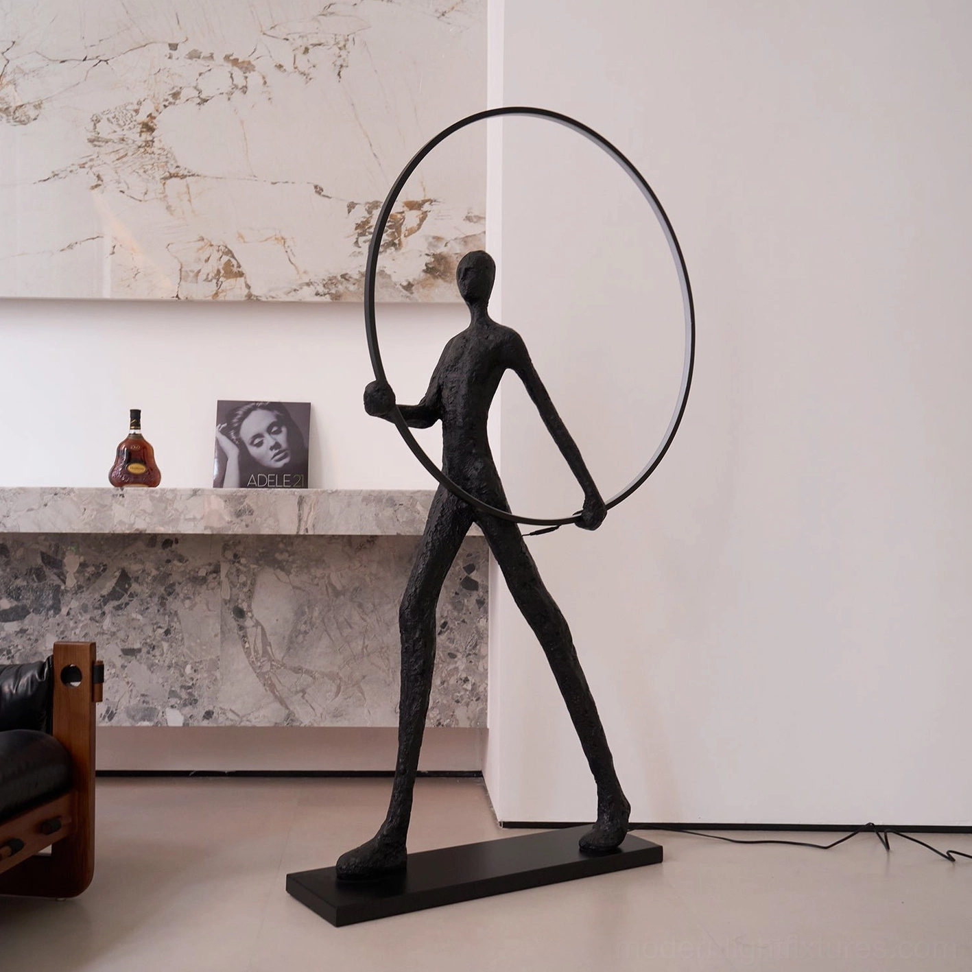 Contemporary art deco floor lamp with black human sculpture and geometric LED light ring, minimalist residential setting