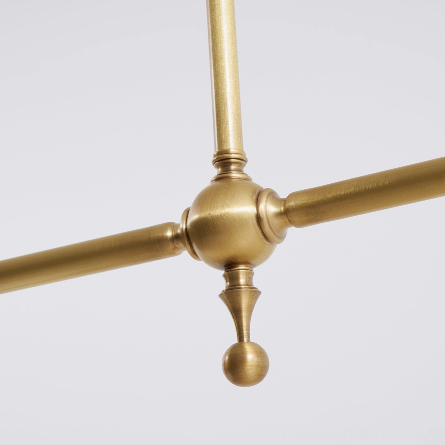 Aged brass frame linear pendant fixture with ceramic shades providing balanced ambient lighting for residential spaces