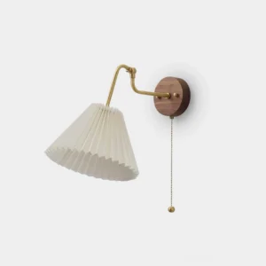 Aine pleated wall sconce with brass arm and walnut wood base, front three-quarter studio view against white background
