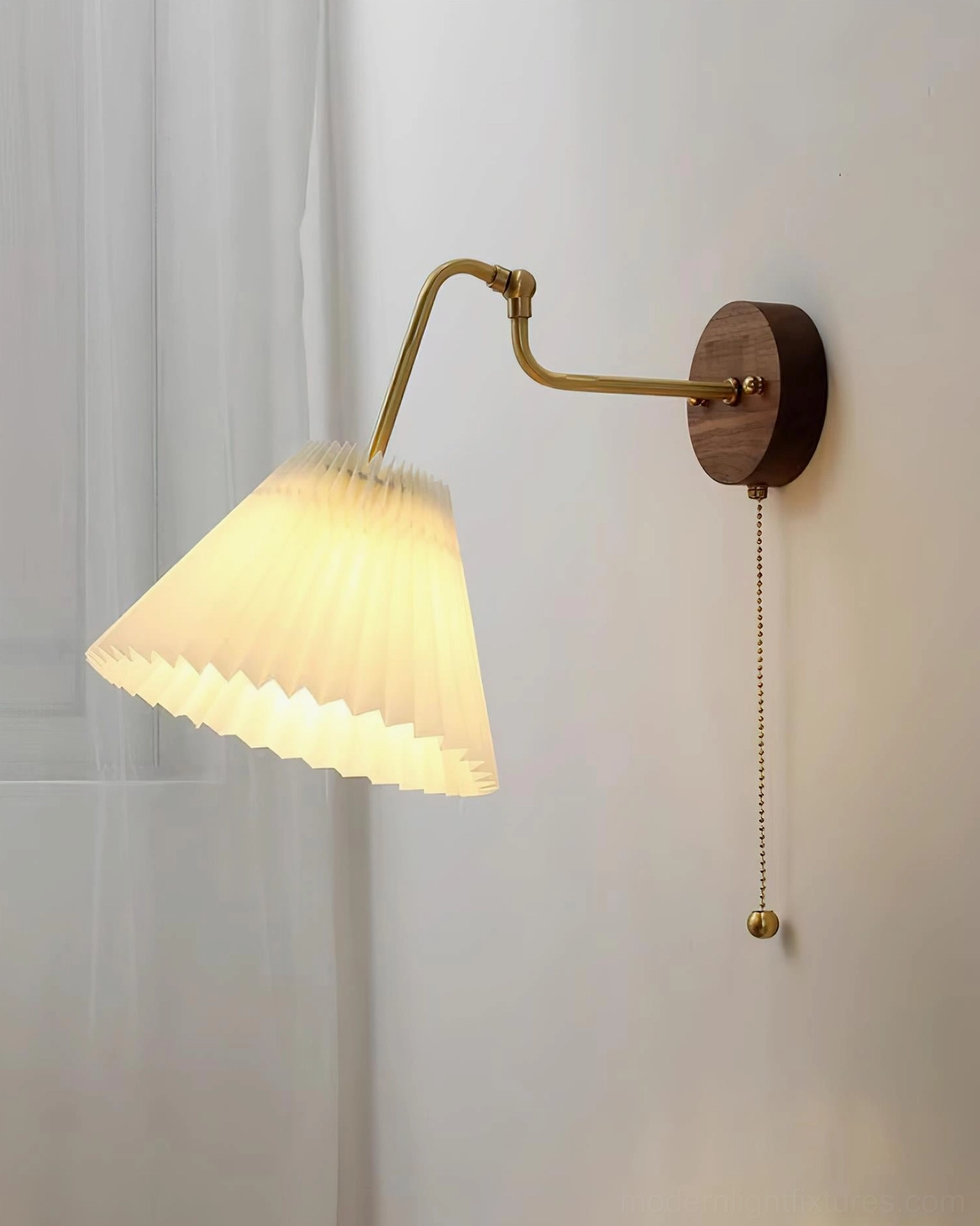 Aine pleated wall sconce illuminated side view, warm diffused light from pleated shade, mounted on indoor wall