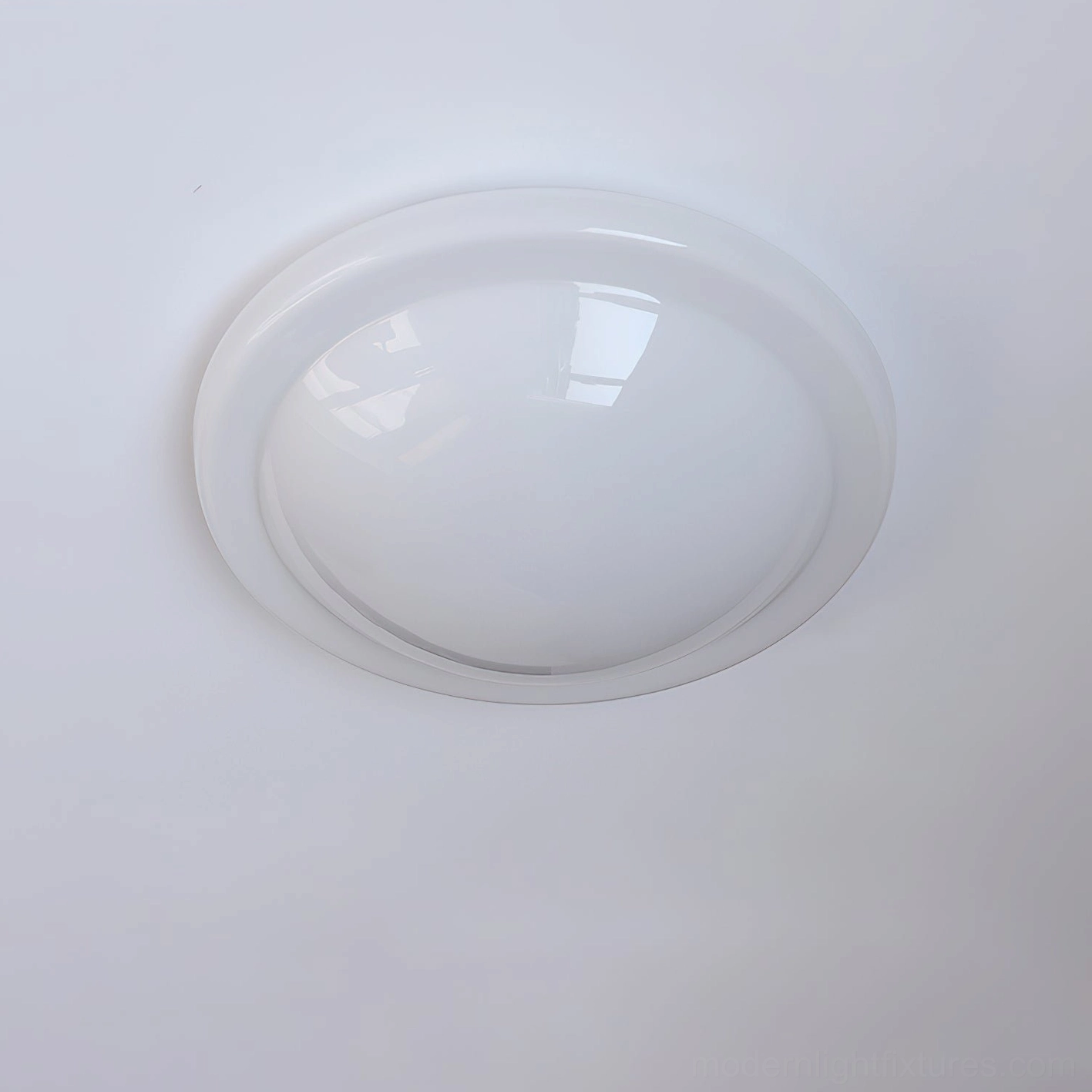 Top-down view of Aire flush ceiling light featuring clear acrylic smooth dome and thin metallic rim in studio lighting
