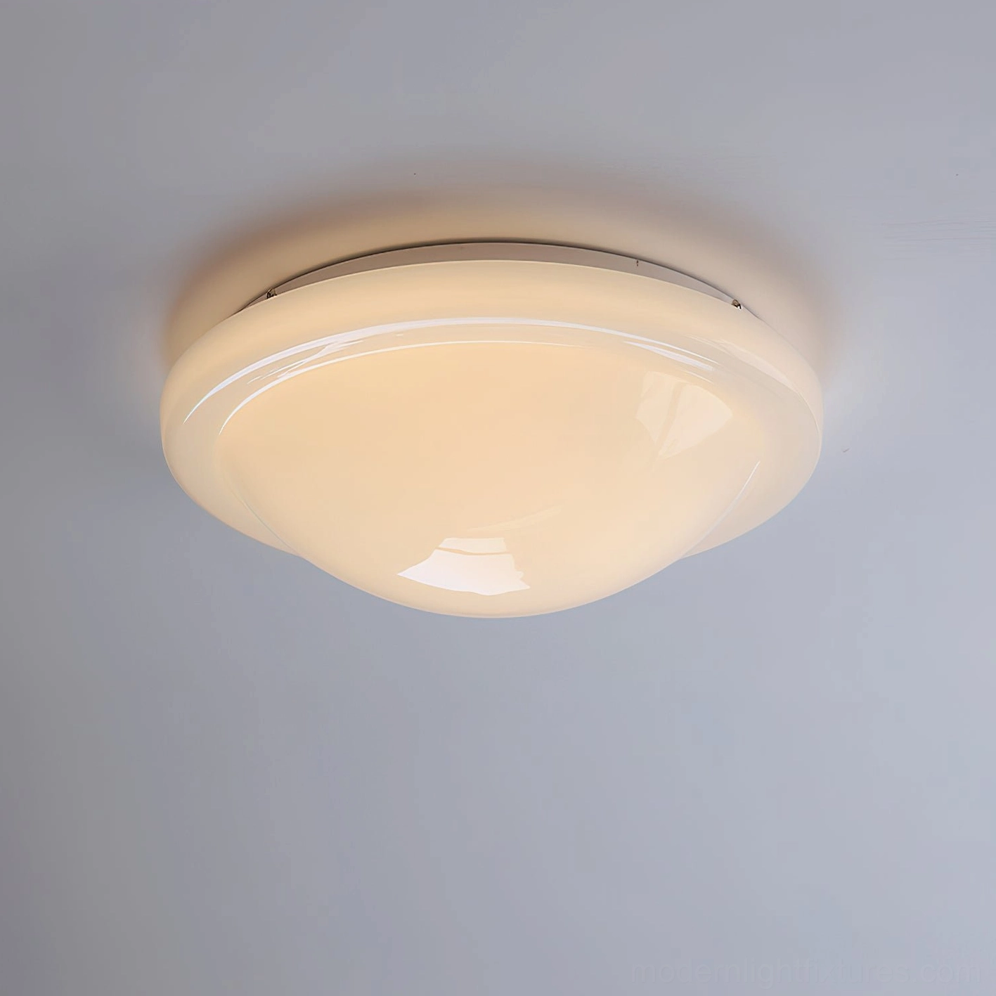 Aire semi-dome warm white ceiling light fixture illuminated showing slim white mounting base and warm glowing glass shade