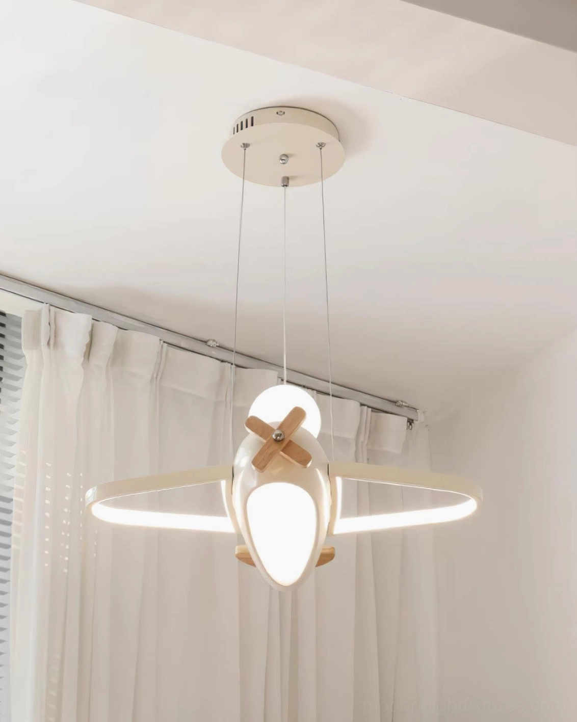 Layered lighting setup with airplane pendant lamp paired with bedside reading light in children's bedroom design