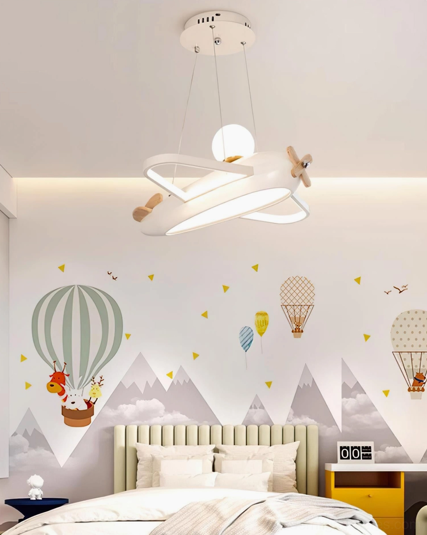 White airplane ceiling pendant lamp installed above bed in hot air balloon themed kids bedroom with warm 3000K lighting