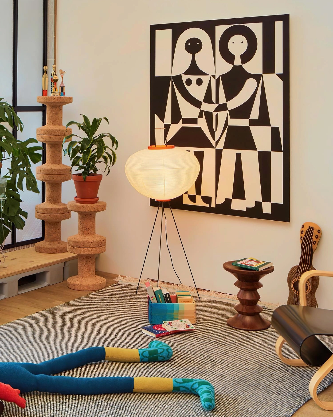 Akari 10A floor lamp in Japanese playroom corner with abstract wall art and potted plants, warm white glow