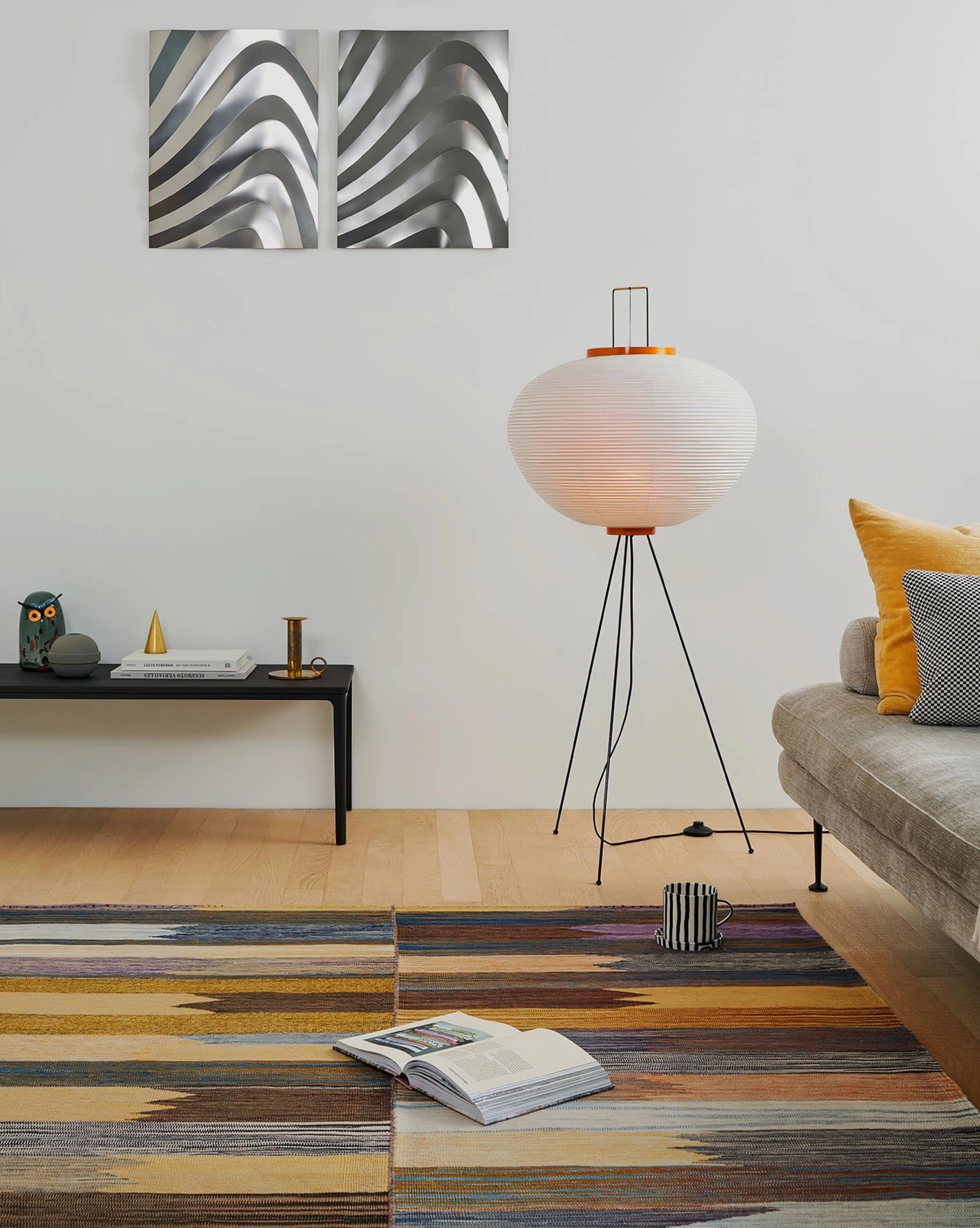 Akari 10A floor lamp in minimalist Nordic living room with striped area rug and fabric sofa, white shade detail