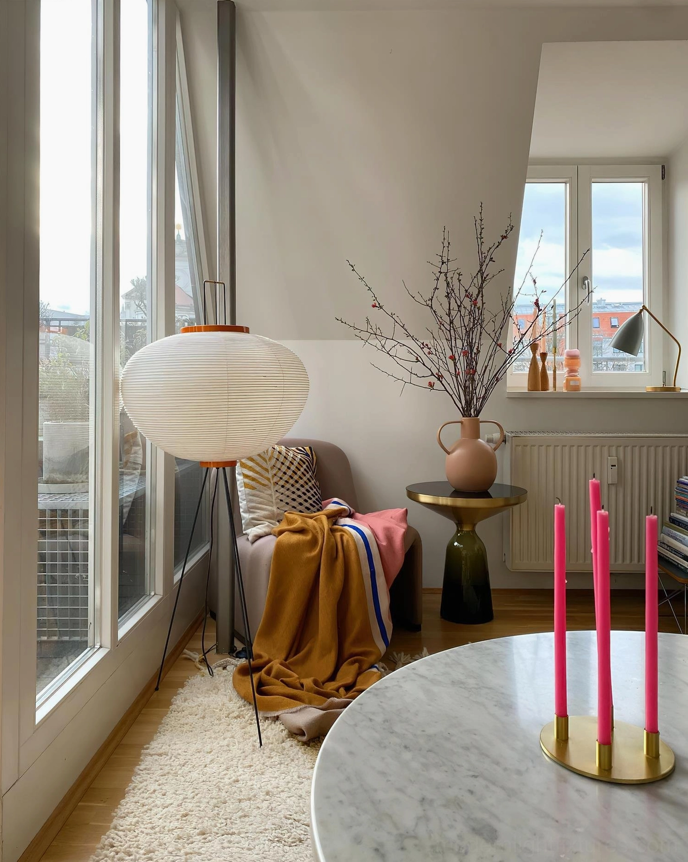 Akari 10A floor lamp by window in reading nook with throw blanket and decorative vase, unlit state