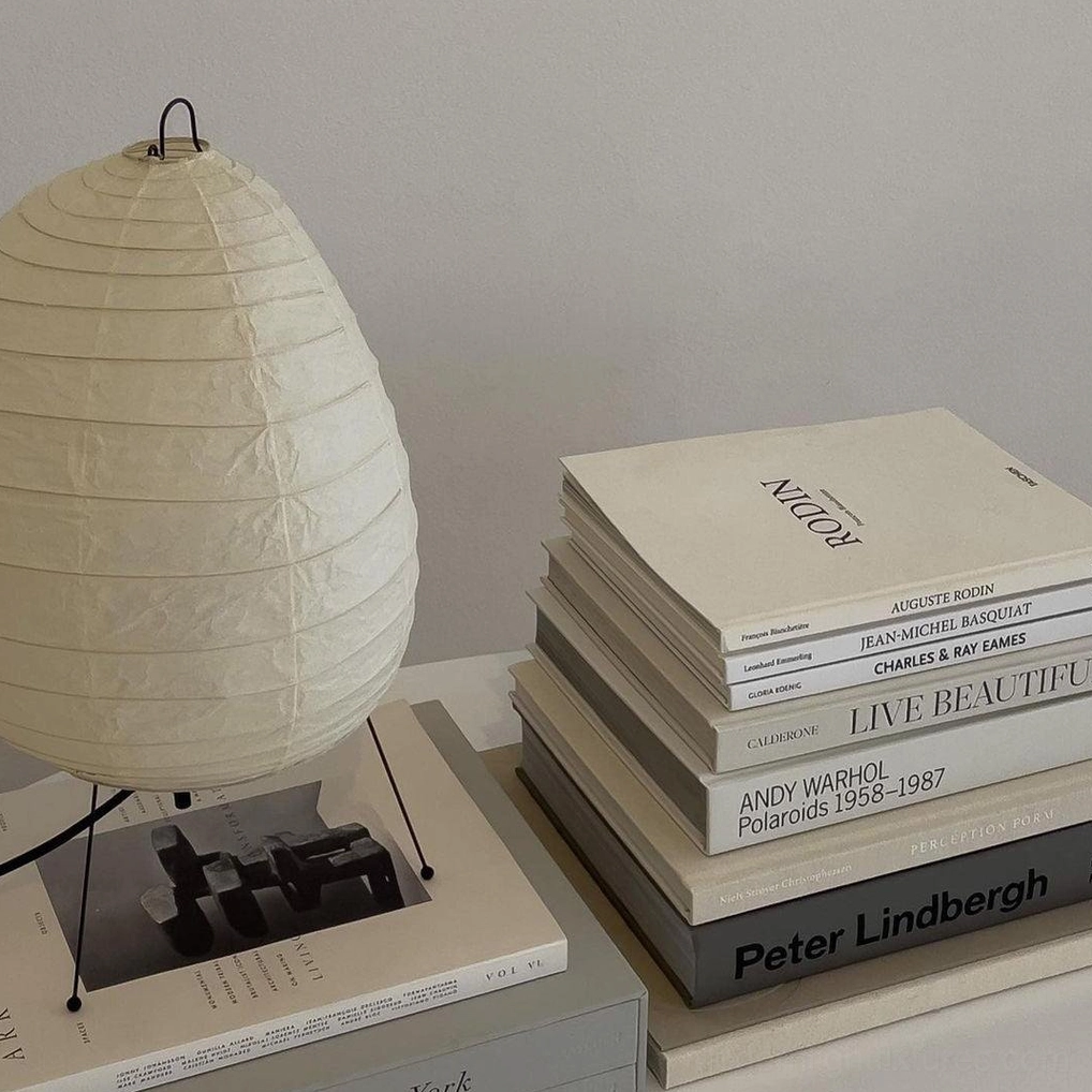 Akari 1N washi paper table lamp base detail showing sculptural steel wire tripod construction and open three-leg design