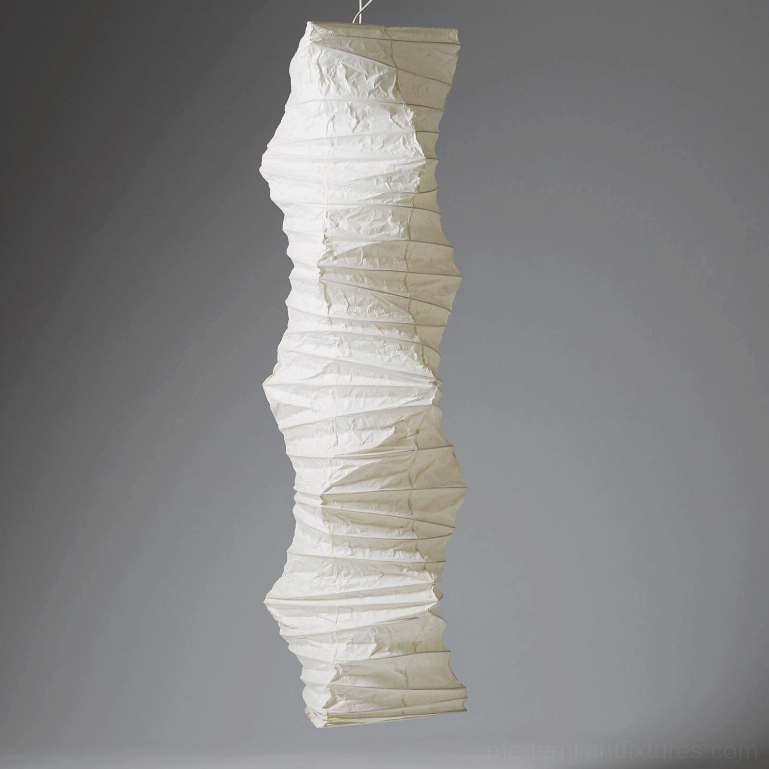 Akari 33N Japanese paper pendant lamp on gray studio backdrop showing delicate wrinkled surface texture in pure off-white