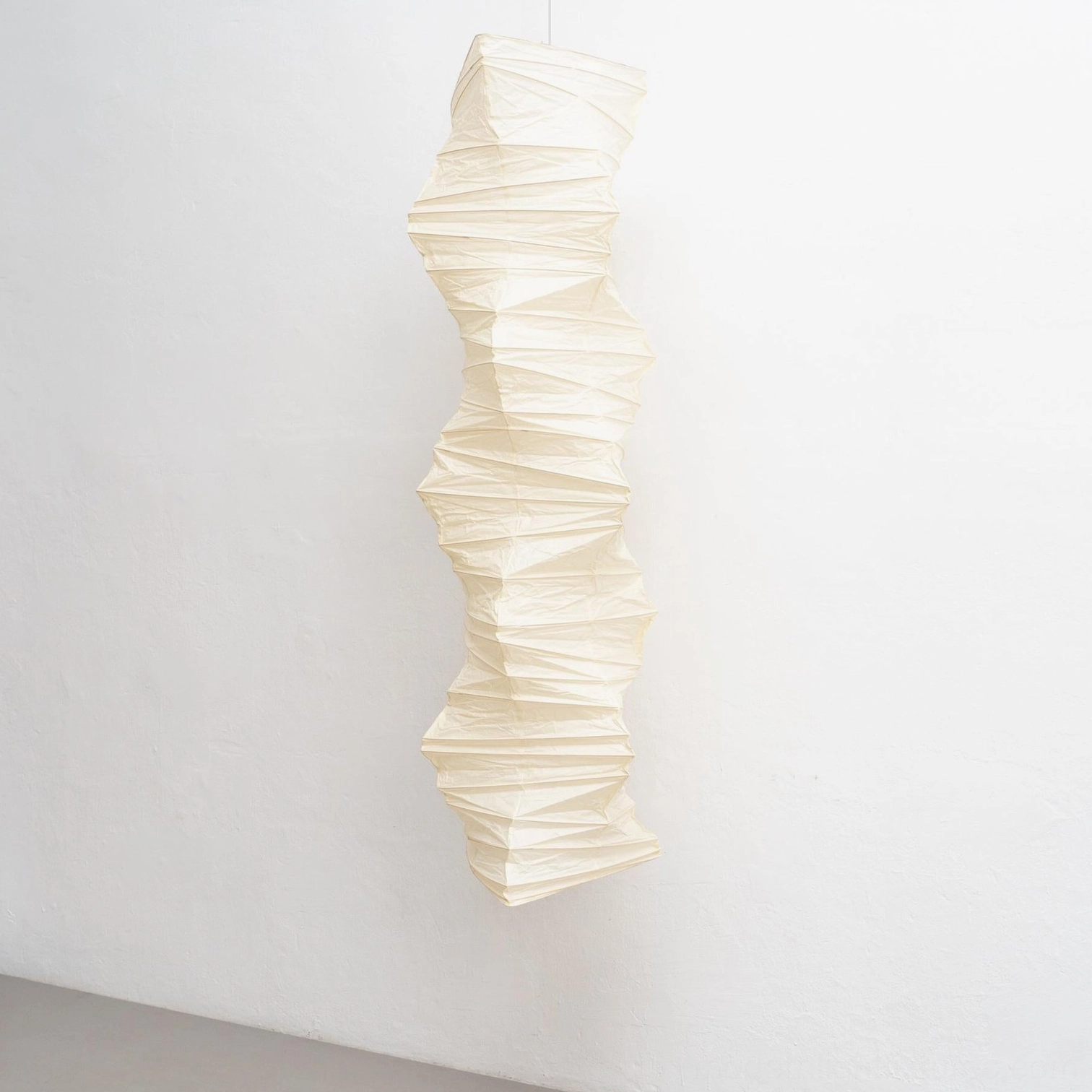 Akari 33N pendant lamp illuminated showing warm light diffusion through textured white paper shade