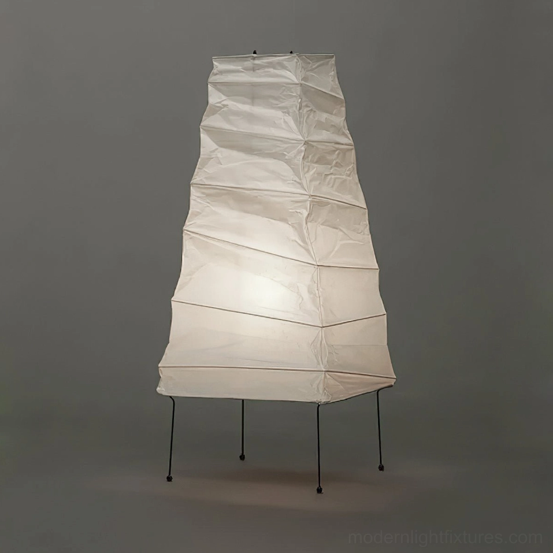 Akari 4N lit table lamp with soft warm illumination from folded paper shade
