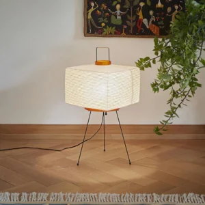 Akari 7A hand-folded paper table lamp three-quarter angle view living room with green plant