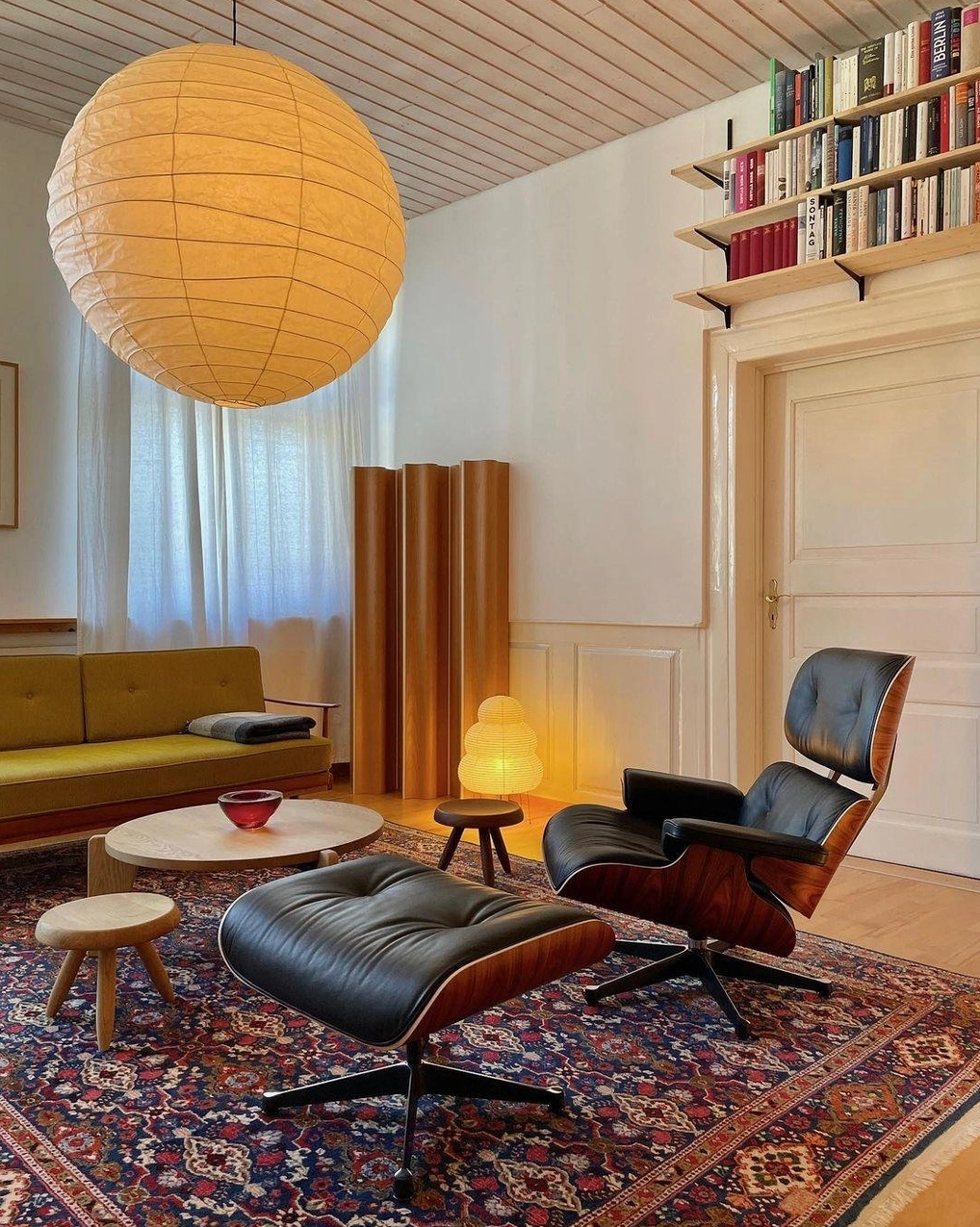 Japanese Washi pendant lamp in mid-century lounge with area rug - wide angle view showing ambient warm lighting