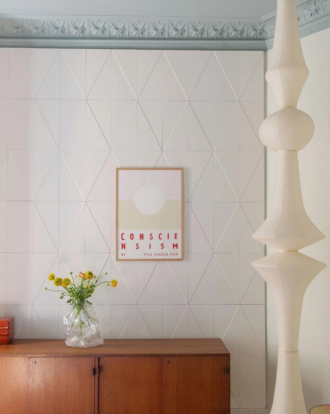 Akari E spherical and tapered white paper pendant lamp in textured plaster home hallway