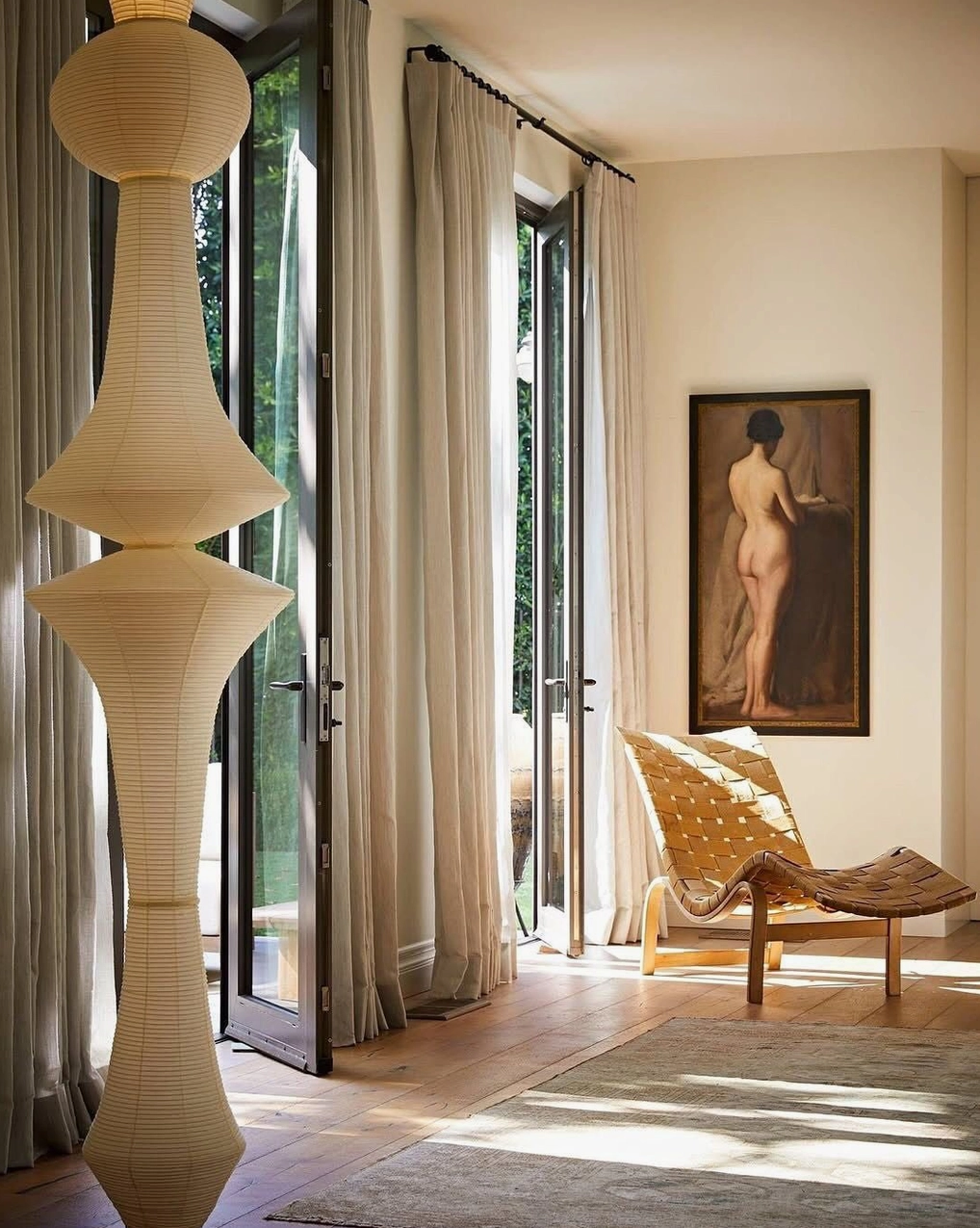 Akari E stacked white paper pendant lamp in sunlit modern living room with french doors and wabi-sabi decor