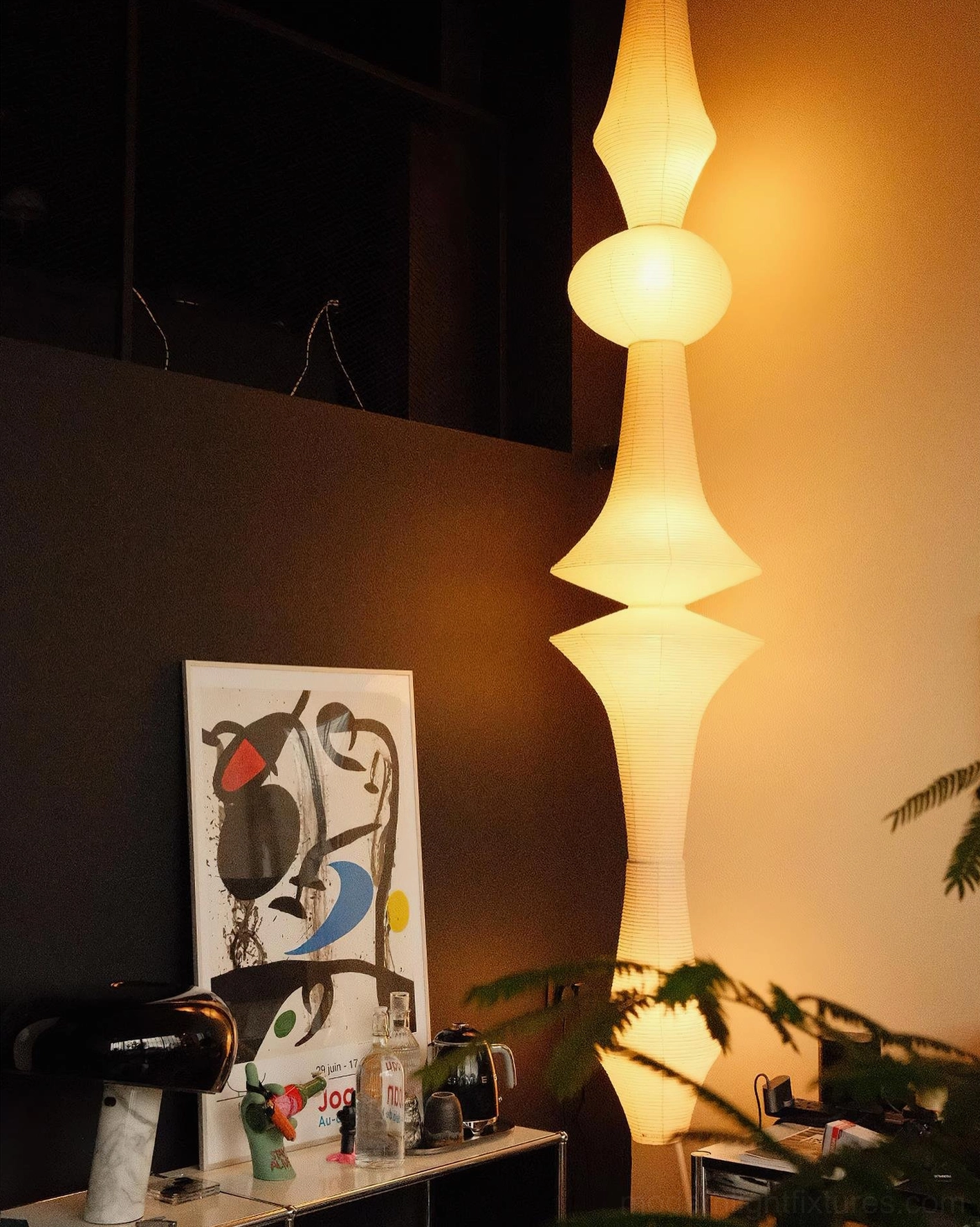 Akari E off-white paper pendant lamp with warm glow in cozy home bar nook, side angle view