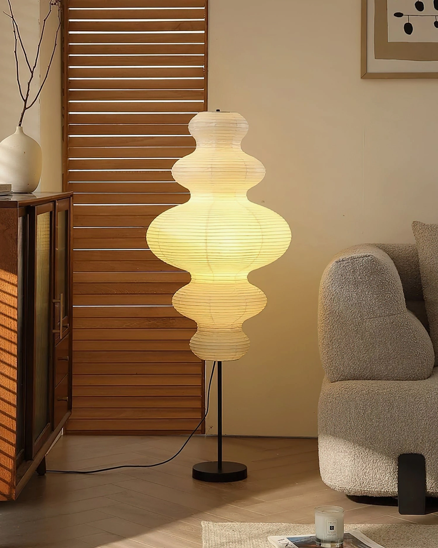 Lit Akari Juni floor lamp casting warm yellow glow in Japanese-style minimalist interior