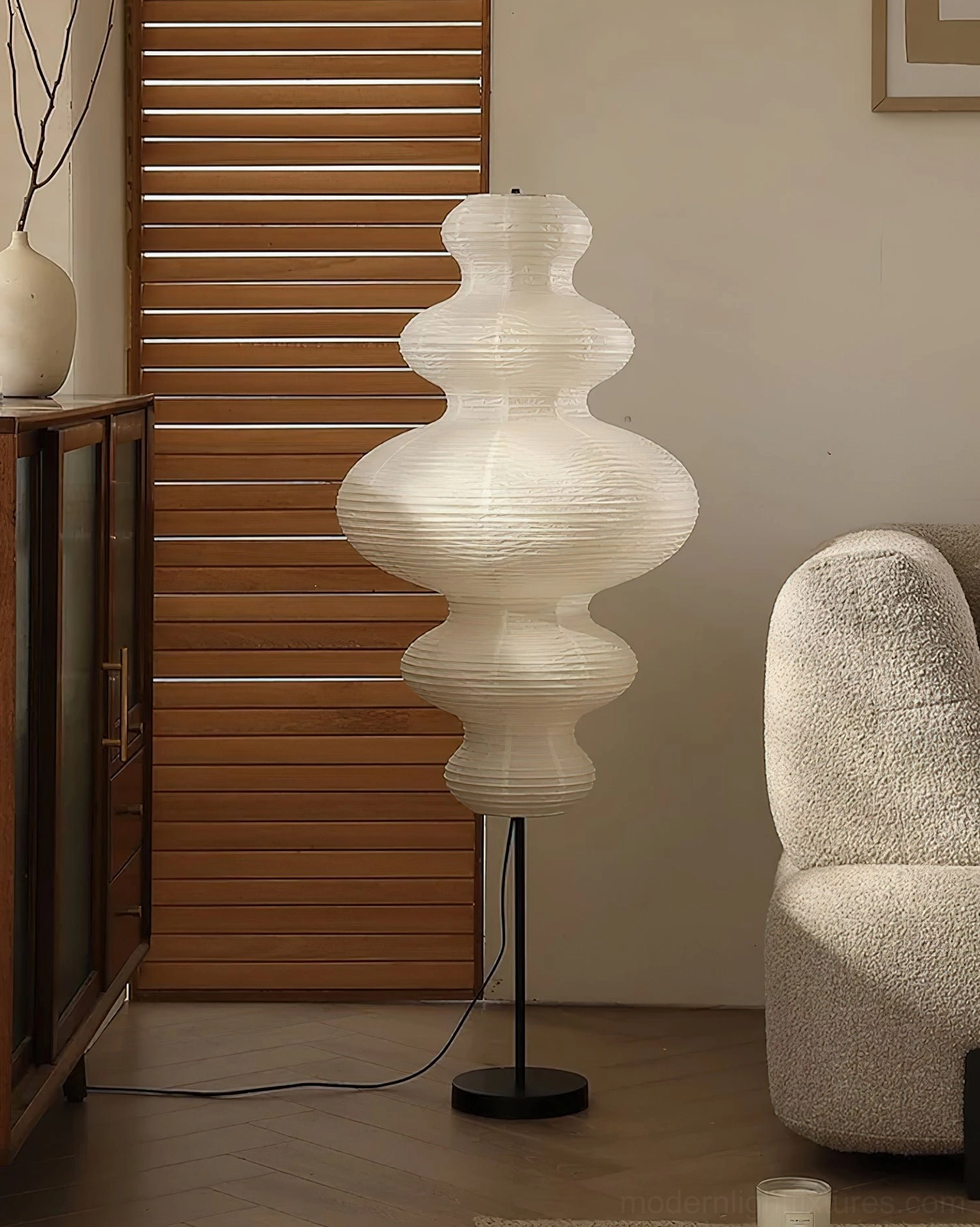 Sleek black metal base and pole of Akari Juni floor lamp with smooth white paper diffuser shade