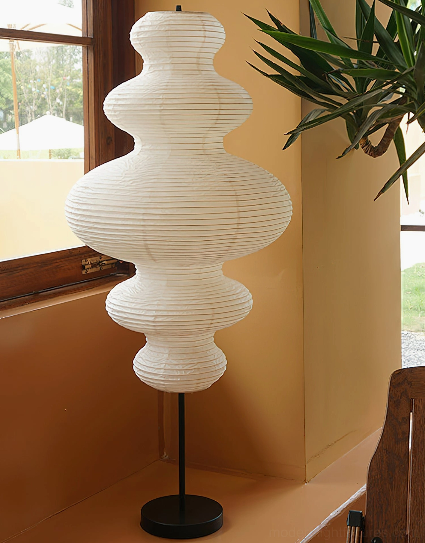 Textured white Xuan paper shade floor lamp beside window with plants, wabi-sabi design