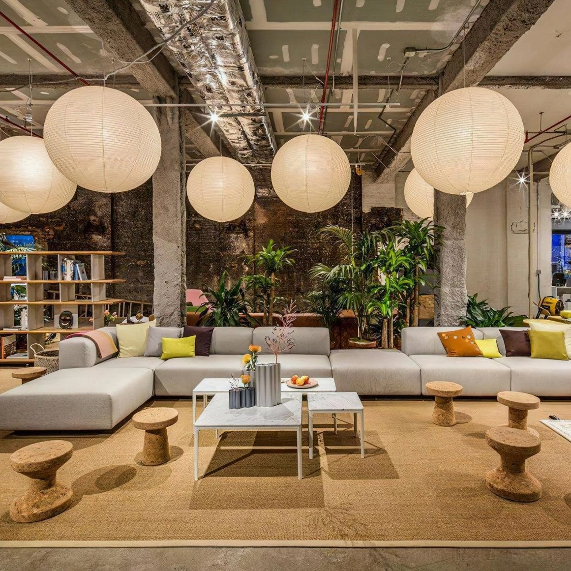 Multiple Akari A Series paper pendant lamps with industrial ceiling in open-concept lounge