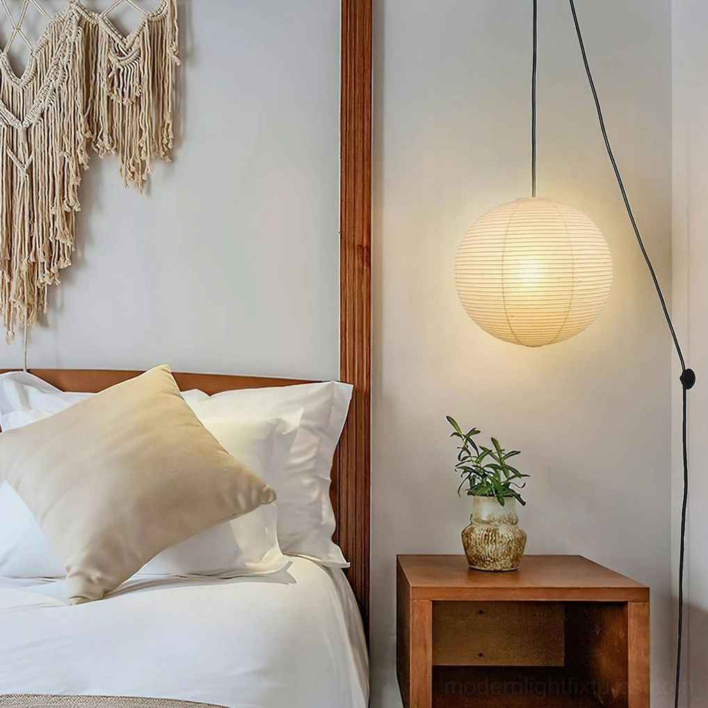 Plug-in Akari A Series paper pendant lamp in bedroom with boho rustic aesthetic and black cord