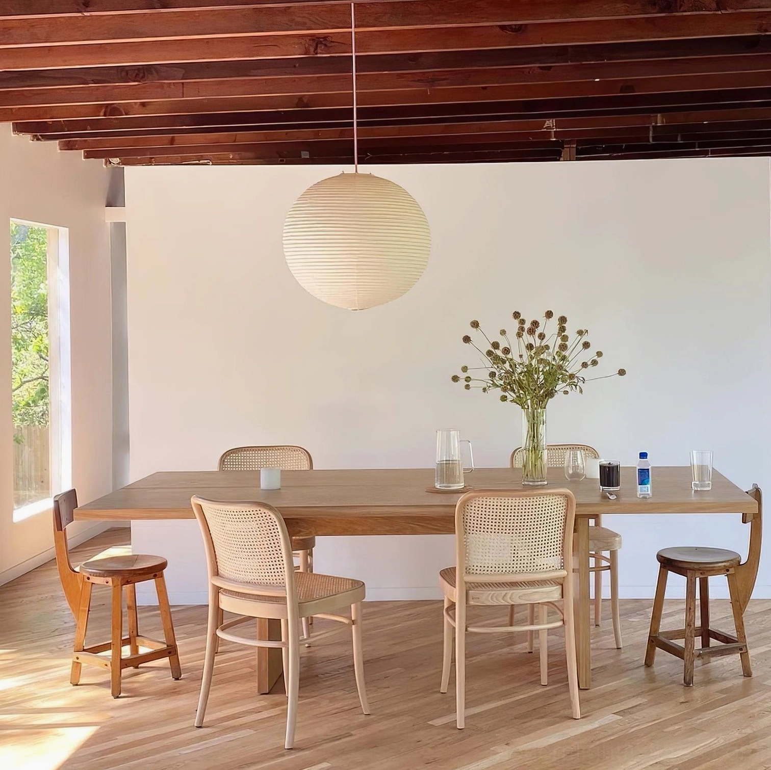 Akari pendant lamp in wooden-beam dining area with warm natural lighting