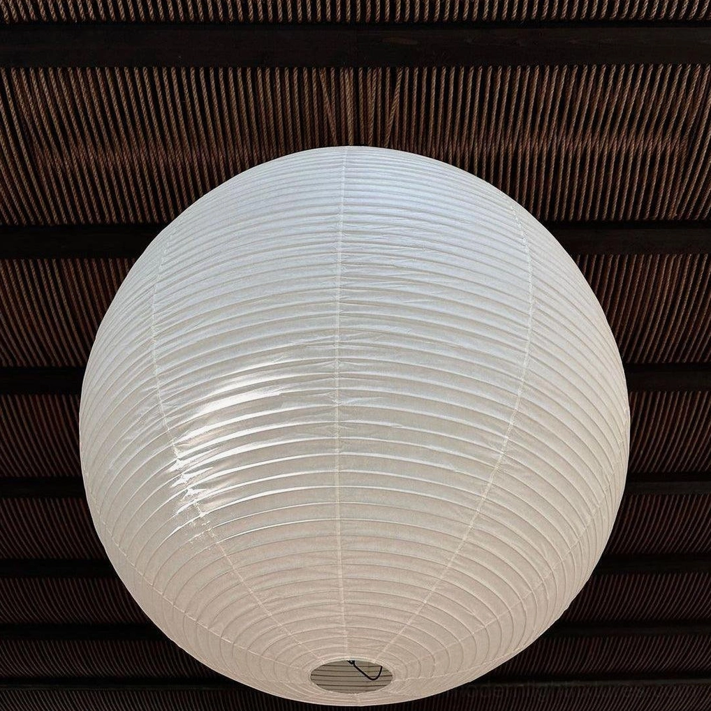 Close-up overhead view of Akari pendant lamp showing white cotton paper texture and ribbed details