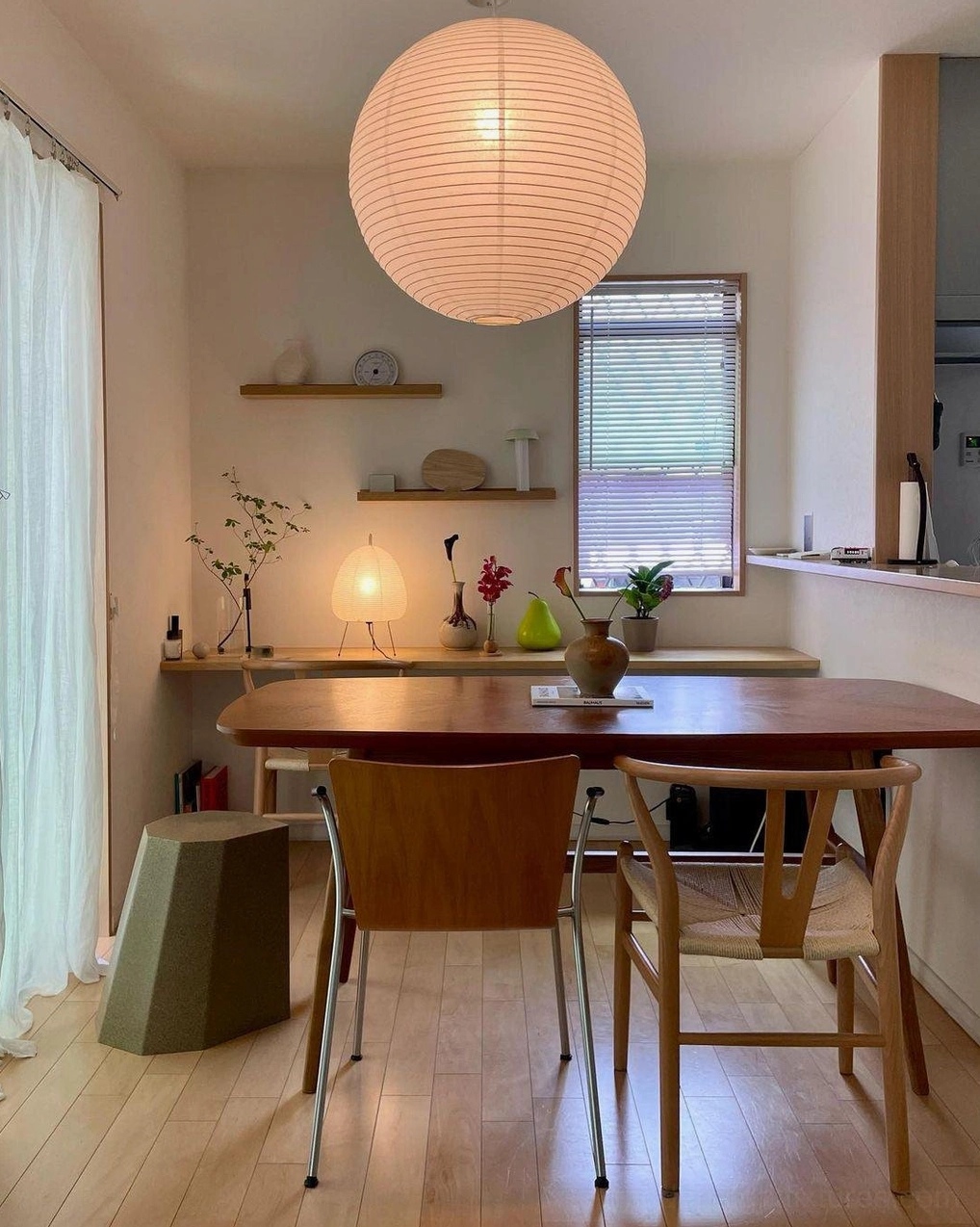 Akari Round pendant lamp dimmed low creating warm amber glow in evening interior