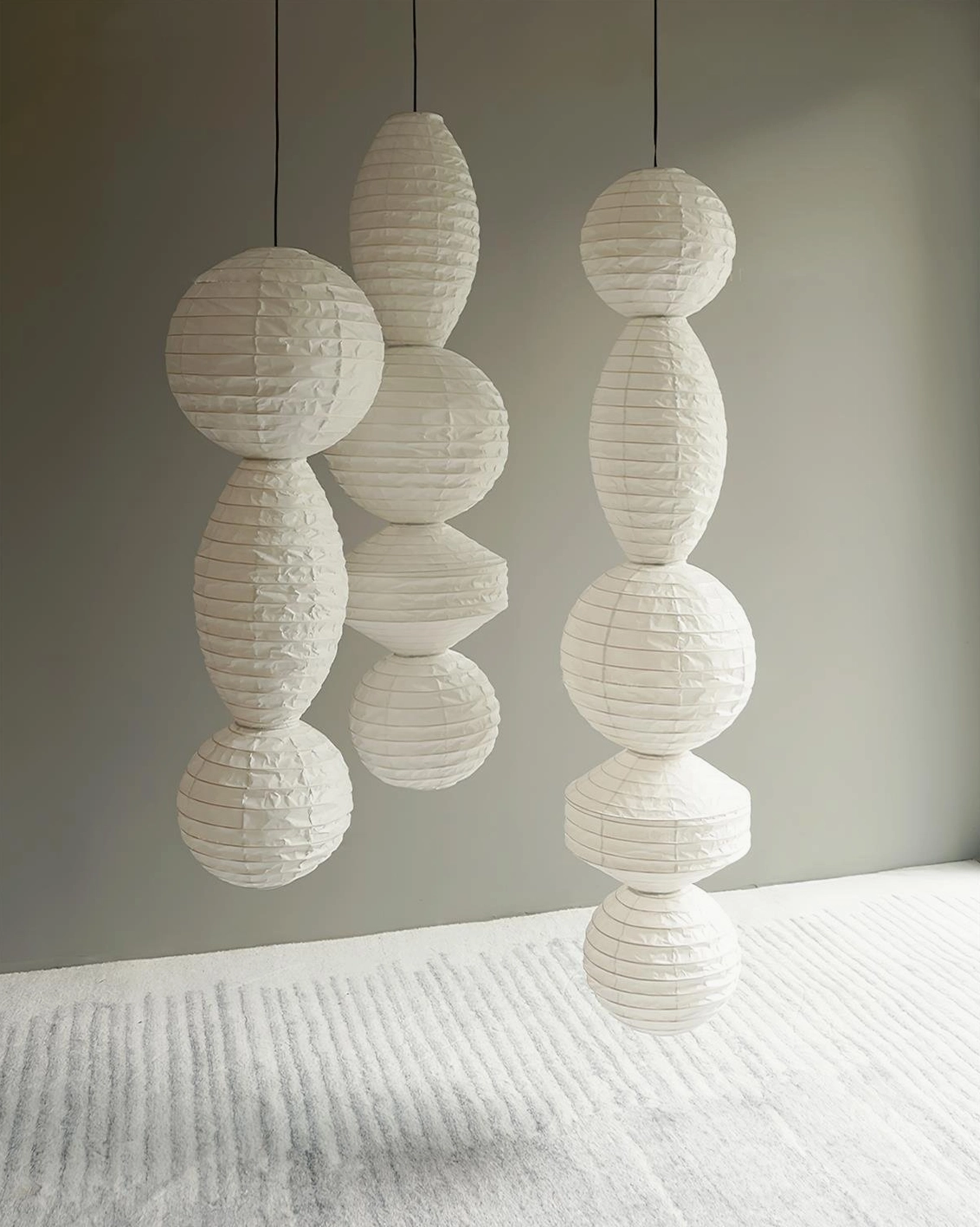 Dual Akari Tayo stacked paper pendant lights in bright modern room with textured rug