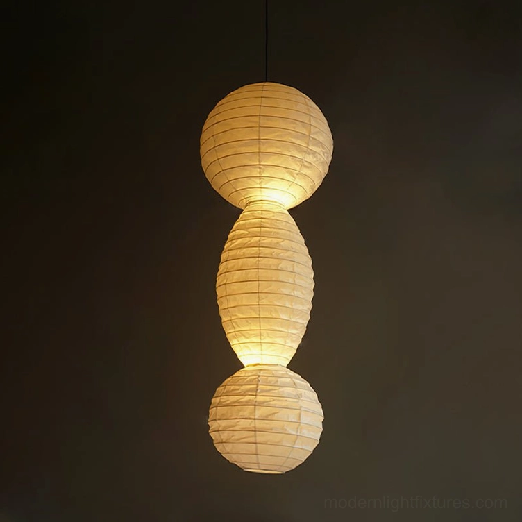 Akari Tayo crinkled paper pendant light with warm illumination against dark interior wall