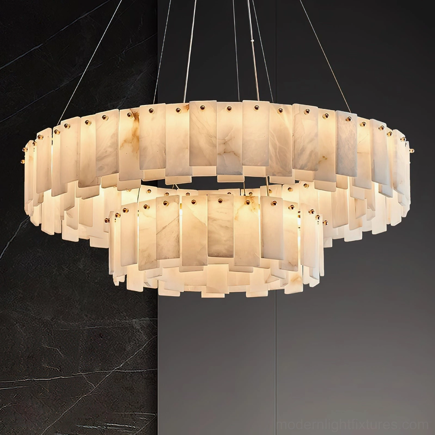 Close-up detail of two-tier alabaster chandelier showing natural stone veining and illuminated layers against dark marble background, modern luxury pendant lighting