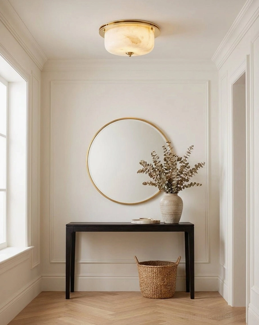 Justice alabaster flush mount lighting foyer entryway with herringbone wood floor, console table, and round mirror