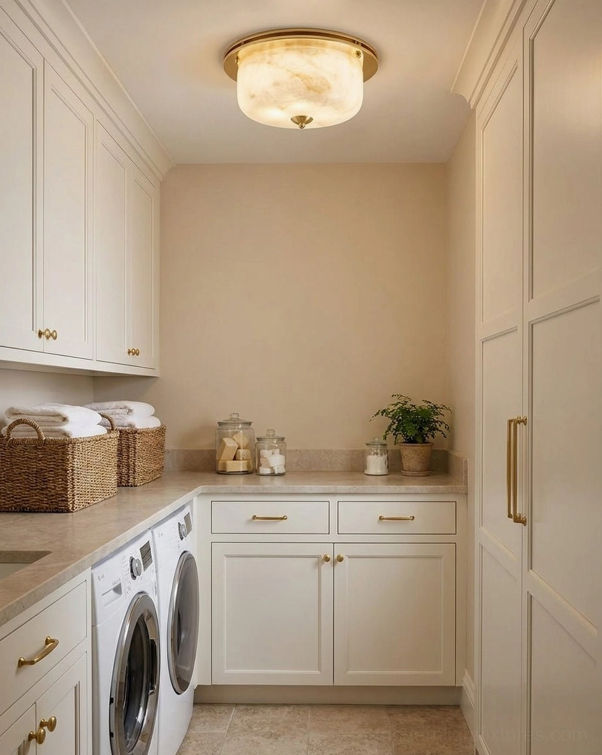 Justice alabaster and brass flush mount ceiling light in bright clean pantry utility room with white cabinetry