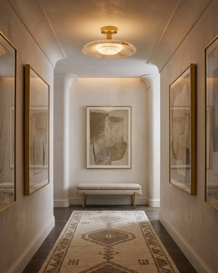 Flush mount alabaster fixture illuminating art gallery hallway with neutral decor