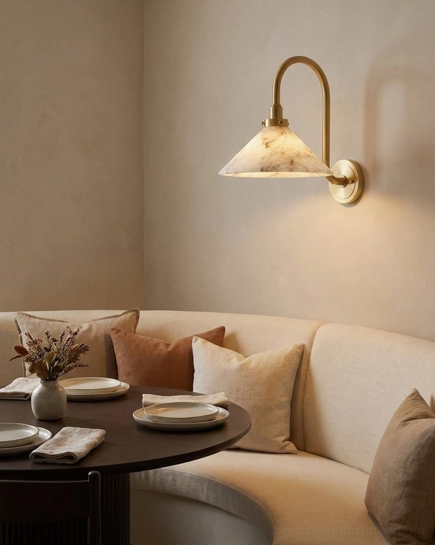 Lunelle alabaster sconce in dining nook, warm lighting above curved banquette seating