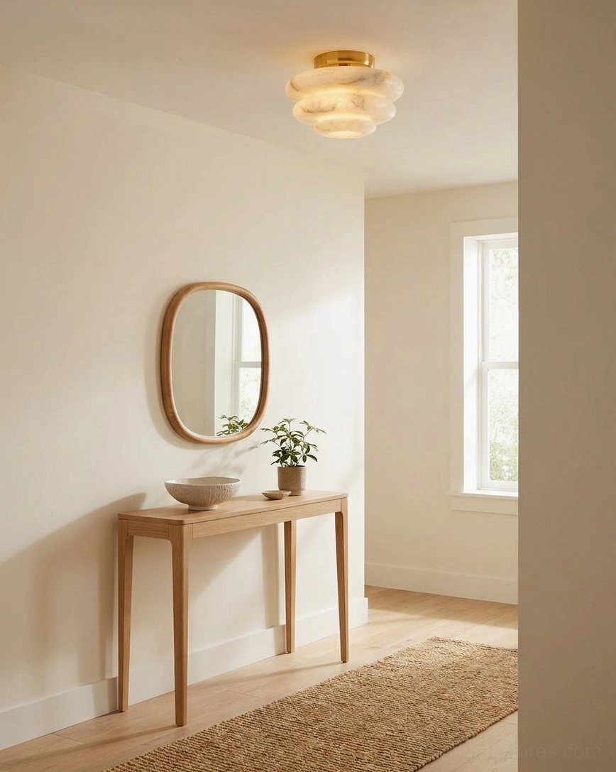Tiered alabaster flush mount in entryway with vanity mirror and wooden console, soft warm light for foyer