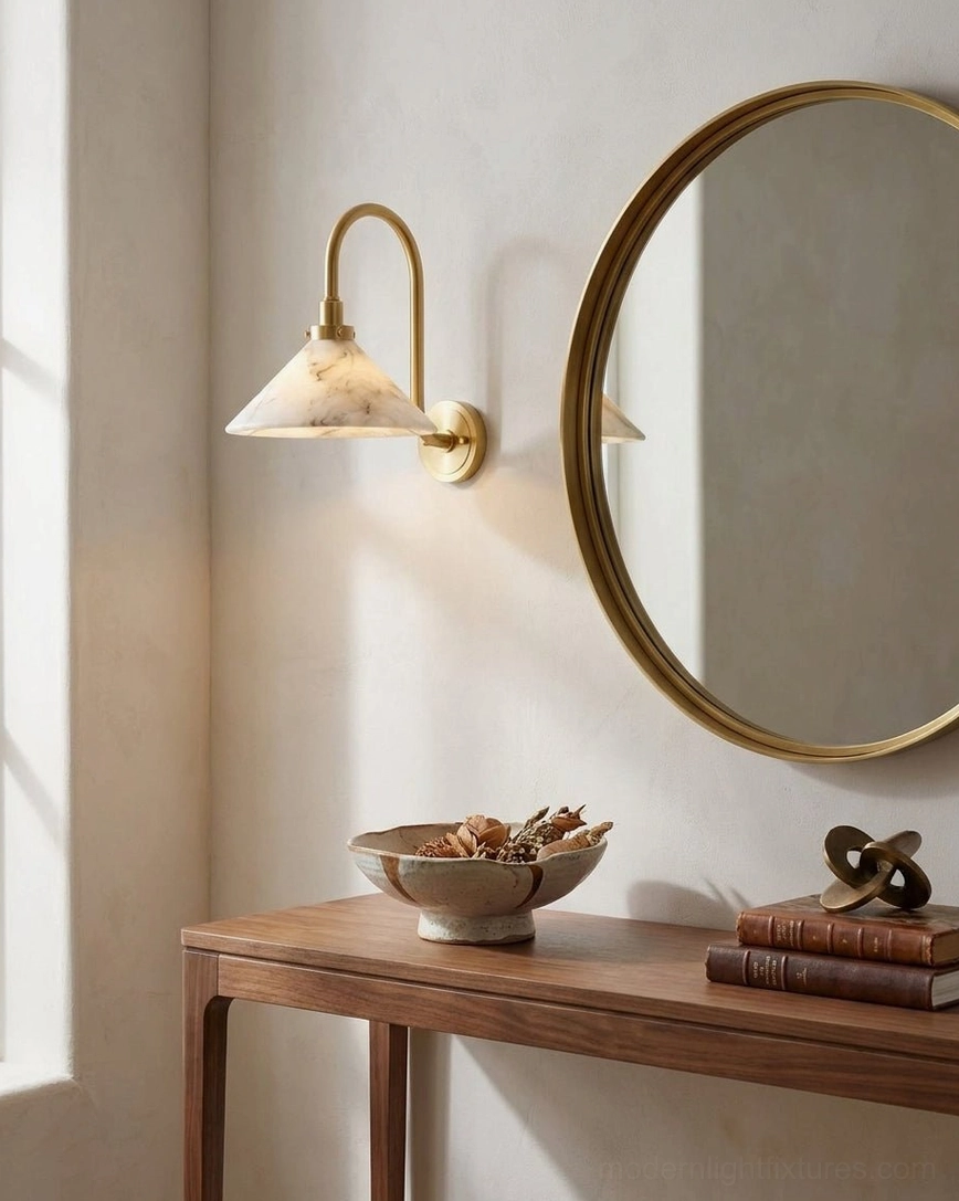 Lunelle wall sconce installed in entryway, flanking gold round mirror above wooden console table